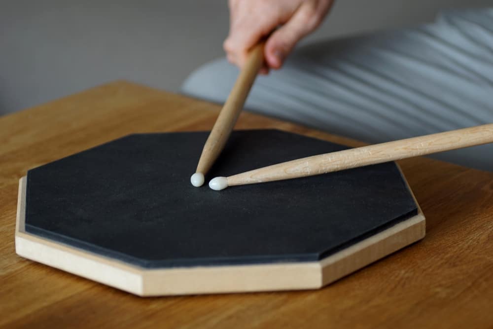 Baterista estudando técnica em pad de estudo, imagem ilustrativa