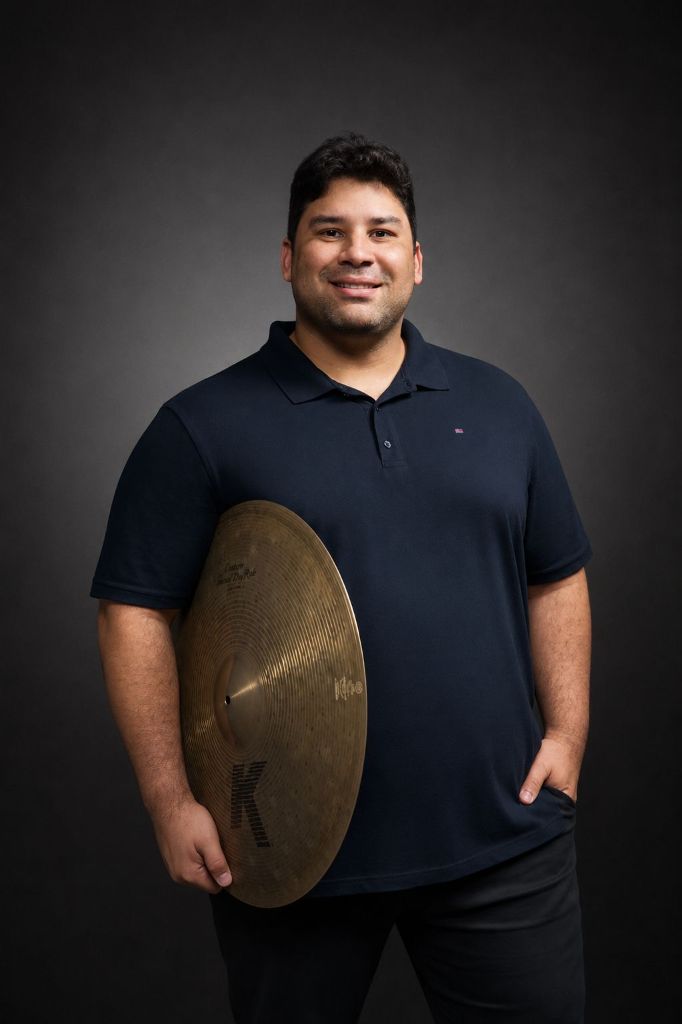 Eduardo Pirajá, baterista e professor, segurando um prato de bateria
