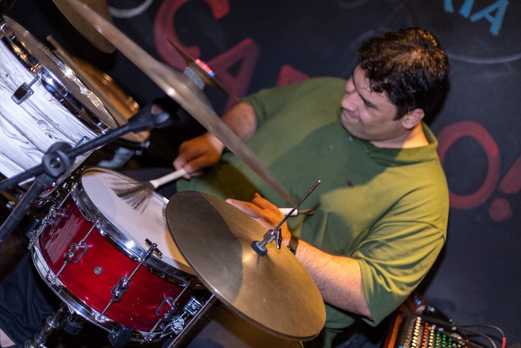 Eduardo Pirajá tocando bateria em close, com baquetas e prato em primeiro plano