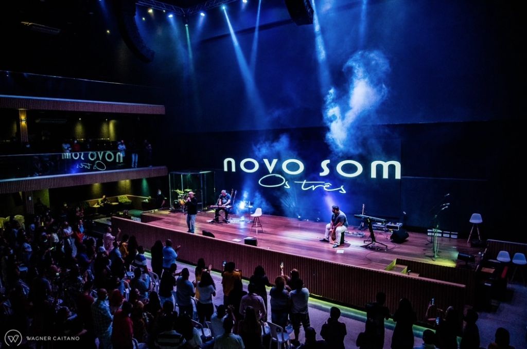 Show ao vivo em palco com iluminação azul e plateia lotada